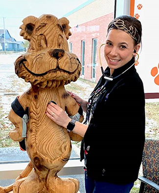 photo of Margaret Snead and carved wooden tiger
